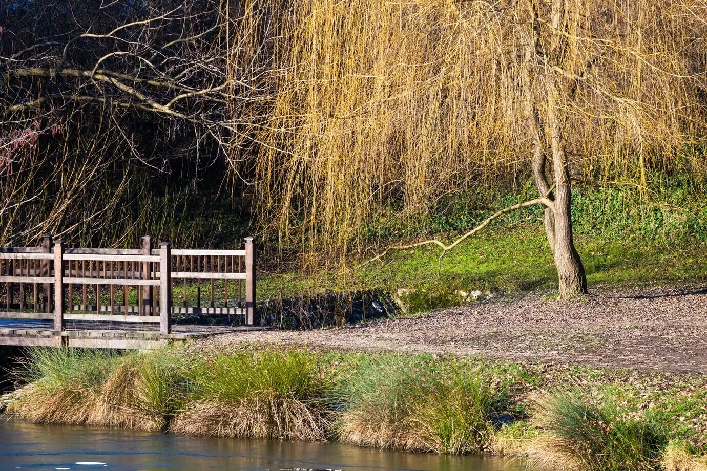 Wunderschöne Aufnahme einer kleinen Brücke über einem See im Maksimir-Park in Zagreb, Kroatien, bei Tageslicht.
